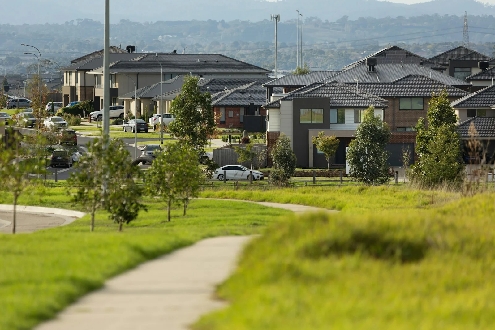 Brick and rendered family homes with tiled roofs in a suburban neighbourhood in Clyde North, Victoria